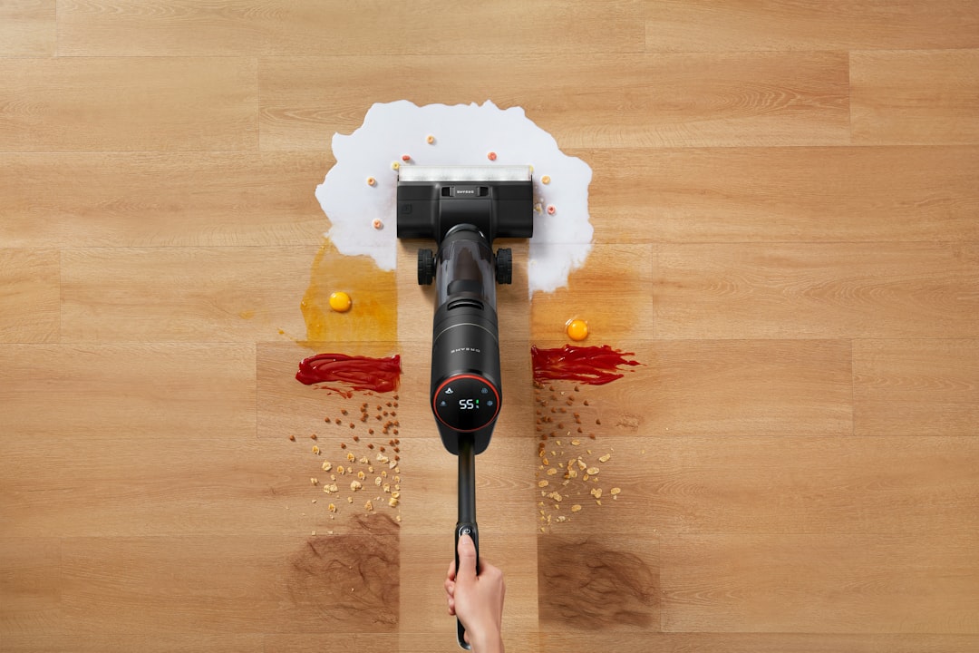 Guided by hand, a Dreame wet dry vacuum moves through kitchen and pet messes, cleaning up different types of spills.